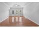 Spacious bedroom with hardwood floors, ceiling fan, and natural light from three windows at 1019 Hillsdale Dr., Little River, SC 29566