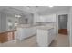 Open kitchen with white cabinets, center island, and modern sink, seamlessly connecting to the dining area at 1019 Hillsdale Dr., Little River, SC 29566