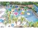 Aerial shot of a ' water park area with colorful play structures, surrounded by lush greenery and lounge chairs at 1105 S Ocean Blvd. # 1106, Myrtle Beach, SC 29577