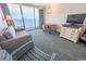 Comfortable living room with ocean view, featuring a sofa, dining table, TV, and stylish décor for a relaxing stay at 1105 S Ocean Blvd. # 1106, Myrtle Beach, SC 29577