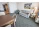 The living room features a gray sofa and a small dining table, complemented by light-colored walls and ocean-themed décor at 1105 S Ocean Blvd. # 1106, Myrtle Beach, SC 29577