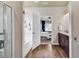 Bright bathroom featuring wood-look flooring, a white soaking tub and a view into the Primary bedroom at 725 Salerno Circle # A, Myrtle Beach, SC 29579