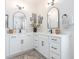 Bright bathroom with double sinks, white cabinets, marble countertops, modern fixtures and arched mirrors at 780 Old Murrells Inlet Rd., Murrells Inlet, SC 29576
