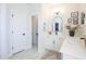 Bright bathroom with single sink, white cabinets, marble countertops, modern fixtures and arched mirror at 780 Old Murrells Inlet Rd., Murrells Inlet, SC 29576