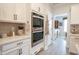 Well-equipped kitchen with built-in ovens, white cabinetry, and a view into the adjacent dining area at 780 Old Murrells Inlet Rd., Murrells Inlet, SC 29576