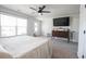 Bright main bedroom with ceiling fan, door to exterior, and flat screen TV on wall above antique credenza at 780 Old Murrells Inlet Rd., Murrells Inlet, SC 29576