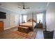 This primary bedroom boasts a four poster bed, wood floors, ceiling fan and windows with valances at 780 Old Murrells Inlet Rd., Murrells Inlet, SC 29576