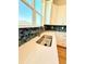 Close-up of a kitchen sink with quartz countertops and a blue tile backsplash at 8628 Farrier Dr., Myrtle Beach, SC 29588