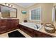 Luxurious bathroom featuring a jacuzzi tub, custom cabinetry, and a large window at 9785 Anchor Dr., Longs, SC 29568
