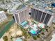 Aerial view of a resort featuring multiple pools, lush landscaping, and surrounding neighborhood at 100 N Beach Blvd. # 1608, North Myrtle Beach, SC 29582