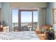 Relaxing main bedroom with a balcony view, comfortable chair, and elegant furnishings at 100 N Beach Blvd. # 1608, North Myrtle Beach, SC 29582