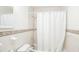 Bright bathroom featuring tile walls, a decorative accent border, and a shower with a white curtain at 1019 Prince St., Georgetown, SC 29440