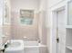 This bathroom offers a tub with shower, tiled walls, and a window with blinds for natural light at 1019 Prince St., Georgetown, SC 29440