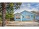 Exterior view of the blue house with a paved area and mature trees at 1019 Prince St., Georgetown, SC 29440