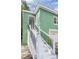 Entry staircase with black railings leads to this green home with white trim accents at 1019 Prince St., Georgetown, SC 29440