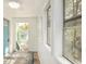 Enclosed porch with a blue door, white walls, and windows overlooking the lush yard at 1019 Prince St., Georgetown, SC 29440