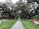 A beautiful garden path lined with colorful flowers and mature trees creates a serene and picturesque scene at 115 Northbrook Dr, Murrells Inlet, SC 29576