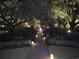 Illuminated brick walkway through a lush, landscaped garden at night, creating a magical ambiance at 115 Northbrook Dr, Murrells Inlet, SC 29576