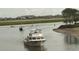 Scenic view of boats navigating a waterway surrounded by lush greenery and waterfront homes under an overcast sky at 115 Northbrook Dr, Murrells Inlet, SC 29576