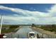 Scenic view of a serene waterway with boats docked, lush marshland, and a distant skyline under a partly cloudy blue sky at 115 Northbrook Dr, Murrells Inlet, SC 29576