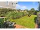 Lush backyard featuring tall grasses, manicured hedges, and a charming bird bath at 1257 Ocean Blvd., Holden Beach, NC 28462