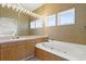 Relaxing bathroom features a jetted tub, large mirror with Hollywood lights and multiple windows for natural light at 1257 Ocean Blvd., Holden Beach, NC 28462