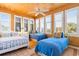 Sunlit bedroom features wood paneled walls, bright windows with shutters, and three twin beds at 1257 Ocean Blvd., Holden Beach, NC 28462