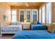 Cozy bedroom with wood paneled walls and bright shuttered windows, featuring two twin beds at 1257 Ocean Blvd., Holden Beach, NC 28462