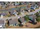 A birds-eye view of a neighborhood with well-maintained landscaping and a tranquil pond at 1439 Castleberry Pl., Myrtle Beach, SC 29588