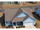 Aerial view of a home features a well-manicured lawn, two-car garage, and a welcoming front porch at 1439 Castleberry Pl., Myrtle Beach, SC 29588