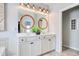 Bright bathroom features a double sink vanity, circular mirrors, modern lighting, and neutral tile flooring at 1439 Castleberry Pl., Myrtle Beach, SC 29588