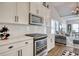 Modern kitchen boasts white cabinets, stainless steel appliances, and a view into the living room with vaulted ceilings at 1439 Castleberry Pl., Myrtle Beach, SC 29588