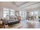 Bright, open-plan living and dining area with a chandelier, large windows, and elegant furnishings on hardwood floors at 1439 Castleberry Pl., Myrtle Beach, SC 29588
