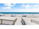 Inviting beach access with wooden walkways leading to a sunny beach with tents and ocean views at 145 South Dunes Dr. # 503, Pawleys Island, SC 29585