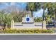 Community entrance sign surrounded by vibrant landscaping and palm trees, marking the entrance to Somerset Cambridge Warwick at 145 South Dunes Dr. # 503, Pawleys Island, SC 29585