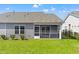 Backyard featuring a screened porch and green lawn, offering a private outdoor space at 1586 Jardine Loop, Little River, SC 29566