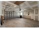 Unfinished garage with concrete floor, exposed ceiling, and garage door in need of repair at 1586 Jardine Loop, Little River, SC 29566