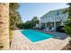 Backyard with a sparkling pool, lush greenery, and ample seating for outdoor relaxation and entertainment at 162 Norris Dr., Pawleys Island, SC 29585