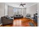 Bright living room with hardwood floors, gray sofa, ceiling fan, and plenty of natural light from the large window at 182 Duck Blind Trail, Myrtle Beach, SC 29588