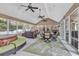 Spacious sunroom filled with natural light, showcasing multiple seating areas, dining, and a relaxing hot tub setup at 182 Duck Blind Trail, Myrtle Beach, SC 29588