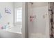 Bright bathroom features a large soaking tub and separate shower with a decorative shower curtain at 211 Copperwood Loop, Conway, SC 29526