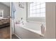 Bright bathroom with a large soaking tub situated under a window with privacy glass at 211 Copperwood Loop, Conway, SC 29526