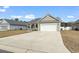 Well-maintained home featuring a two-car garage and long driveway at 211 Copperwood Loop, Conway, SC 29526