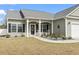 Charming home exterior with landscaped garden, rocking chairs, and a welcoming front porch at 211 Copperwood Loop, Conway, SC 29526