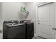 Modern laundry room featuring front loading washer and dryer, storage shelf, and gray walls at 211 Copperwood Loop, Conway, SC 29526