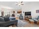 Open-concept living room featuring a ceiling fan, wood-look flooring, and seamless access to the kitchen at 211 Copperwood Loop, Conway, SC 29526