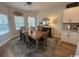 A dining area with a wooden table set, bright windows and modern lighting at 2441 Capri Court, Conway, SC 29527