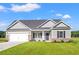 Charming single-story home boasts a two-car garage, well-manicured lawn, and neutral siding at 261 Six Mile Creek Dr., Georgetown, SC 29440