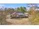 Aerial view of a charming brick home with a welcoming front porch, surrounded by lush greenery and mature trees at 3618 Highway 430, Nichols, SC 29581