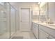 Modern bathroom featuring double sinks, white cabinets, framed mirror, and tiled walk-in shower at 404 Cattle Drive Circle, Myrtle Beach, SC 29588